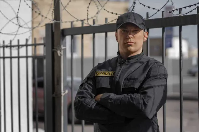 Portrait Male Security Guard With Barbed Wire Fence X - Armed Security Officer Certification study guide