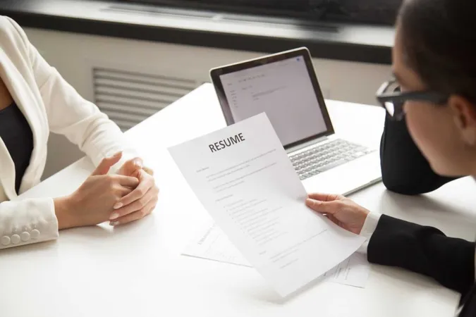 Company Representatives Reading Applicant Resume Hiring X - Certified Human Resources Professional study guide
