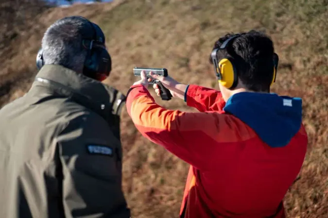 Trainer Helping Young Person Aim With Handgun Combat Training High Quality X - Certified Range Safety Officer study guide